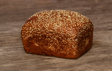 Delicious black bread on old tree background