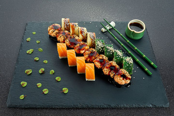 Sushi Set nigiri and sushi rolls on gray stone slate on metal background