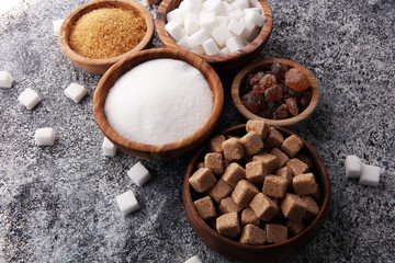 Various types of sugar, brown sugar and white on grey table