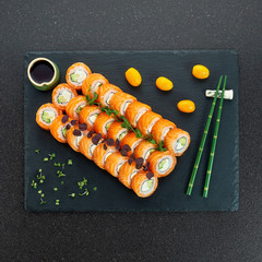 Sushi Set nigiri and sushi rolls on gray stone slate on metal background