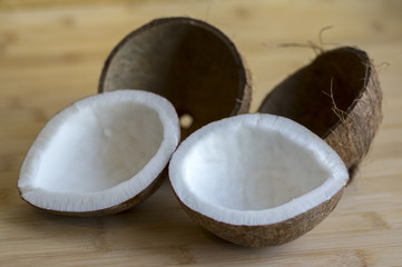 Coconut two halves with nutshells on wooden bambo table