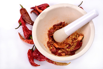 Dried peppers and white mortar on a white background. - obrazy, fototapety, plakaty