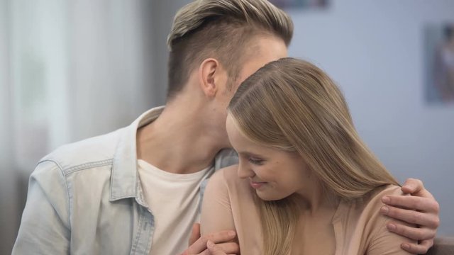 Boy whispering tenderness and compliments to his lovers ear, teenage flirting