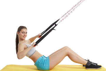 Beautiful fashion girl in a sporty uniform is engaged on an expander.
