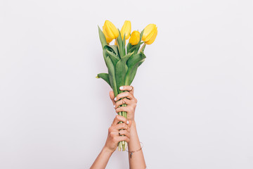 Girl holding a bouquet of yellow tulips