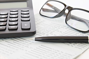 Business, finance, savings, investment or accounting concept : Savings account passbook or financial statement, eyeglasses and calculator on table