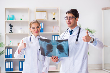 Fototapeta premium Two doctors examining x-ray images of patient for diagnosis