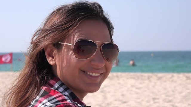 Portrait of beautiful woman on the beach closeup view girl with sunglasses 4K