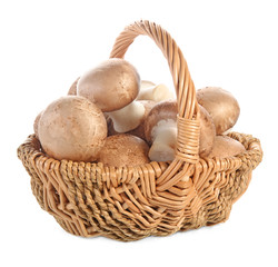 Cremini mushrooms in wicker basket on white background