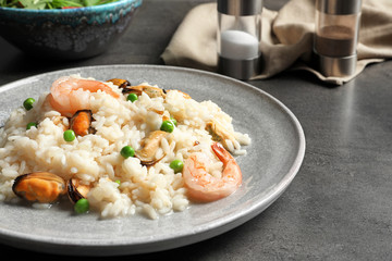 Plate with delicious seafood risotto on table