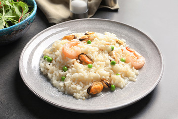 Plate with delicious seafood risotto on table