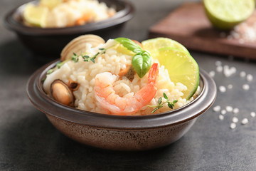 Bowl with delicious seafood risotto on table