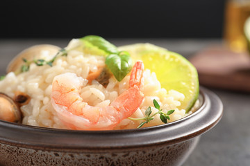 Bowl with delicious seafood risotto on table, closeup