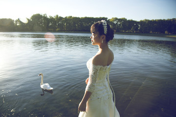 jeune mariée asiatique de profil au bord d'un lac © Michael