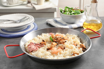 Dish with delicious seafood risotto on table