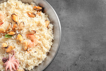 Dish with delicious seafood risotto on table