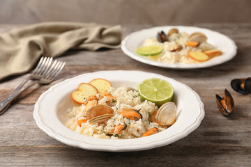 Plate with delicious seafood risotto on wooden table