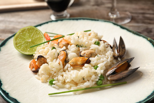 Plate with delicious seafood risotto on table, closeup