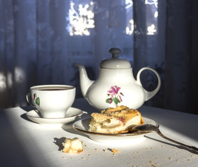 cup of tea tea pot kettle and plate with apple pie on white table 