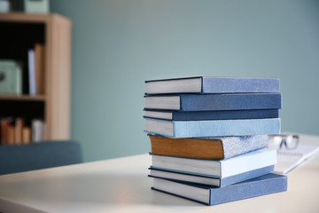 Stack of textbooks on table in student's room. Preparing for exam