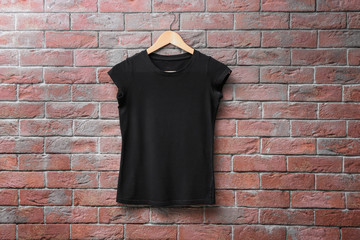 Black t-shirt on brick wall background. Mock up for design