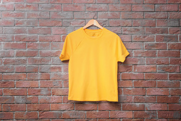 Yellow t-shirt on brick wall background. Mock up for design