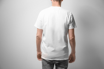 Man in white t-shirt on light background. Mock up for design
