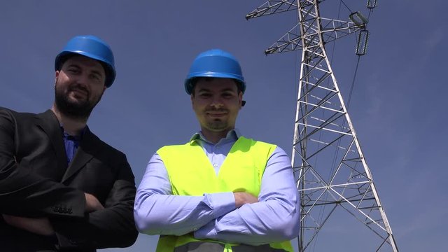 Two businessmen electricity power investment smiling to camera cables pillar 4K