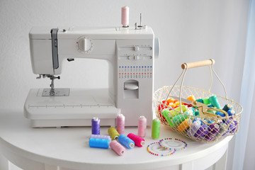 Modern sewing machine with threads on table