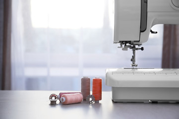 Modern sewing machine with threads on table