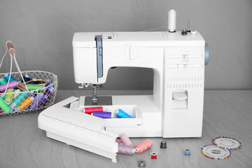 Modern sewing machine with threads on table