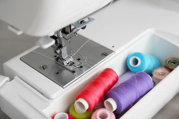 Modern sewing machine with threads, closeup