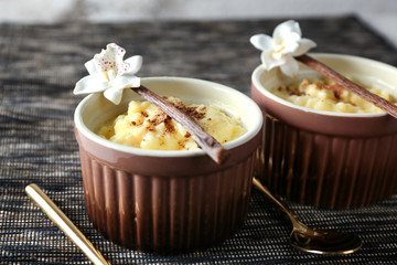 Ramekins with tasty vanilla pudding on table