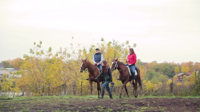 young couple in a Russian village with horses, riding