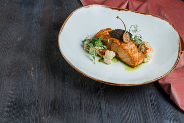grilled salmon with lime, asparagus and cherry tomatoes on white plate