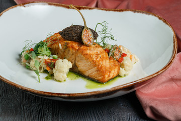 grilled salmon with lime, asparagus and cherry tomatoes on white plate