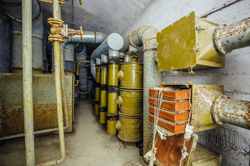 Ventilation chamber in abandoned Soviet bunker. Rusty filter ventilation equipment