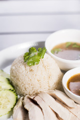 Steamed chicken served over ginger jasmine rice with a side of chicken broth and homemade fermented soy bean sauce