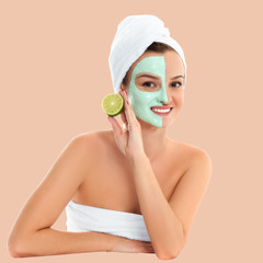 Beautiful woman with clay mask on pastel background. Beauty and spa