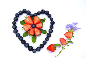 strawberry and blueberry in a shape of a heart on white background