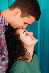 The boyfriend kisses his girlfriend with curly hair in her forehead