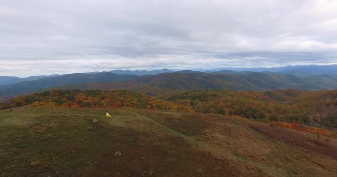 Aerial view Sunset on Max Patch MountainAppalachian Mountains, Tennessee & North Carolina, young woman in yellow dress and cowboy in blue shirt and cowboy hat 4k
