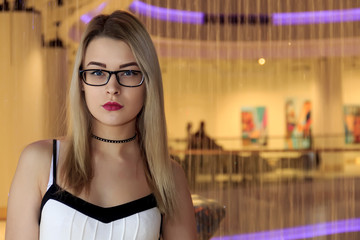 Beautiful blonde with glasses on a light background
