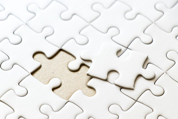 Closed up background of white plain jigsaw wait missing piece to match or fulfill