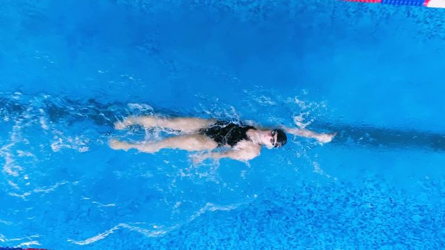 A swimmer controls her breathing during back crawl. 