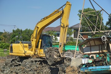 Fototapeta premium Makro excavator working to adjust surface for construction site. labour control makro truck to remove soil and dirt. construction concept