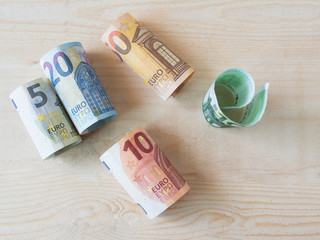 euro currency on wood table.Roll banknote.
