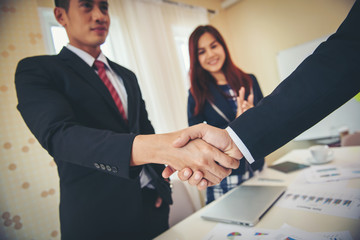 Business people shaking hands while Business people shaking hands while standing at the working place, 