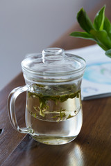 Dragon Well tea leaves being infused in a glass . Close up. 