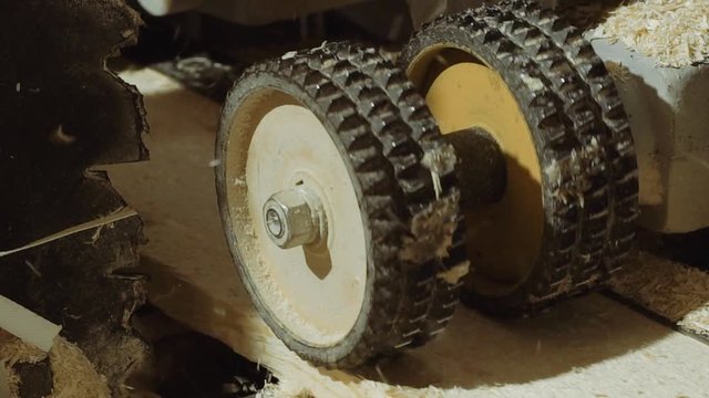 Spinning spiked wheels of plank refiner machine working on wood at sawmill factory, close up